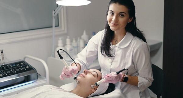 mejores clínicas estéticas - mujer recibiendo de manos de una especialista un tratamiento facial rejuvenecedor en una clínica estética