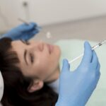 en las mejores clínicas de Botox, un especilista tiene una inyeccion de botox preparada para administrársela a paciente recostada en camilla