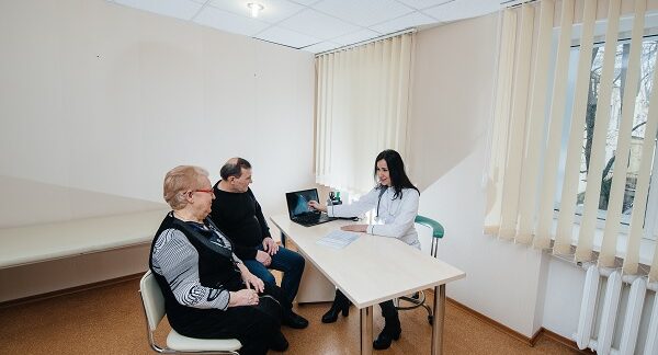 en una de las mejores clínicas de andrología, una especilista da indicaciones medicas a una pareja de pacientes de edad adulta mayor