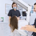 en una de las mejores clínicas dentales, una paciente es atendida por dos especialistas