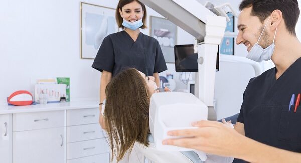 en una de las mejores clínicas dentales, una paciente es atendida por dos especialistas