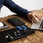una de las tiendas de reparación de computadoras, un técnico repara una laptop