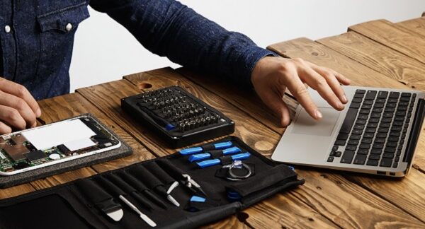 una de las tiendas de reparación de computadoras, un técnico repara una laptop