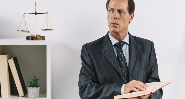 uno de los mejores abogados penalistas, sostiene un libro de leyes en su despacho