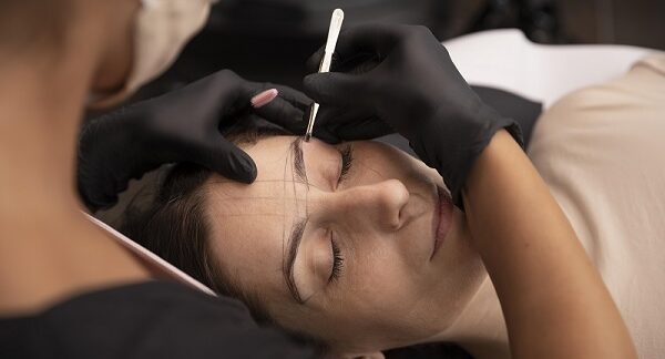 una de los mejores centros de microblading, una mujer se hace un diseño de cejas en un centro especializado