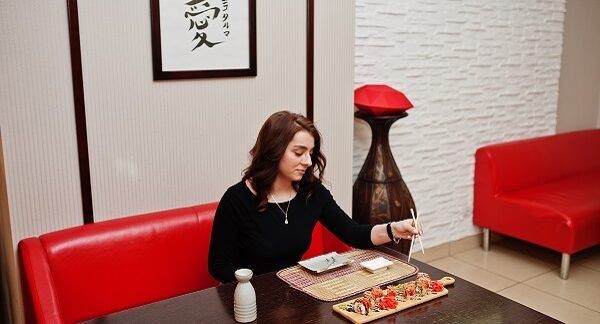 mejores restaurantes japoneses - en uno de los mejores restaurantes japoneses, una joven come sushi
