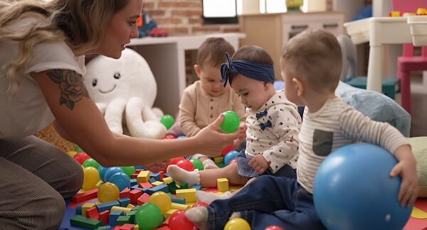 en una de las mejores guarderías, una profesional juega con tres niños pequeños