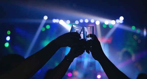 en uno de los mejores clubes, una personas chocan su vasos entre si
