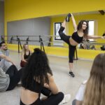en una de las mejores academias de baile, una instructora da una clase a estudiantes que miran con atención