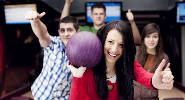 en una de las mejores boleras, un grupo de amigo disfrutan de un juego de bolos
