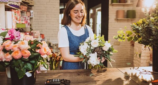 en una de las mejores floristerías, una mujer realiza un arreglo floral