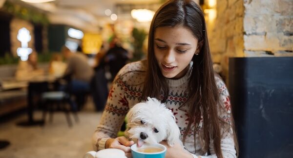Uno de los restaurantes pet friendly, donde se ve a una chica sentada disfrutando de su café con su mascota
