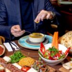 de los restaurantes turcos, un hombre come una sopa, con muchos platos mas de comida en un restaurante turco