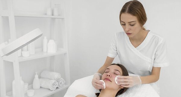 clínicas para el tratamiento del acné, una especialista le trata el rostro a una paciente