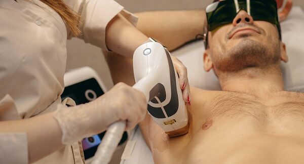 depilación láser para hombres, una especialista le hace depilación laser en la axila a un hombre