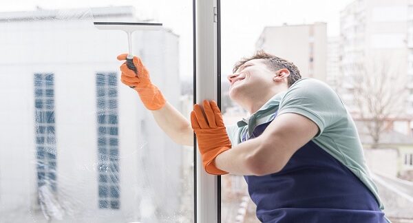 de las empresas de limpieza de ventanas, un hombre hace limpieza a vidrios de una ventana