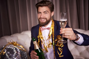 actividades para año nuevo - hombre bebe champán en una fiesta de fin de año