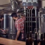 mejores microcervecerías - dos hombre con delantales en el proceso de fabricación de cerveza artesanal