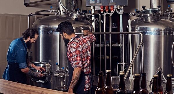 mejores microcervecerías - dos hombre con delantales en el proceso de fabricación de cerveza artesanal