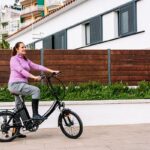 tiendas de bicicletas eléctricas - una mujer adulta montando una bicicleta eléctrica al aire libre