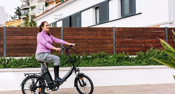 tiendas de bicicletas eléctricas - una mujer adulta montando una bicicleta eléctrica al aire libre