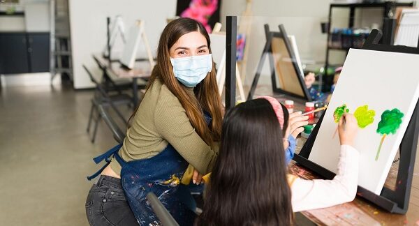 mejores negocios de clases de música - una maestra enseña a niña a pintar
